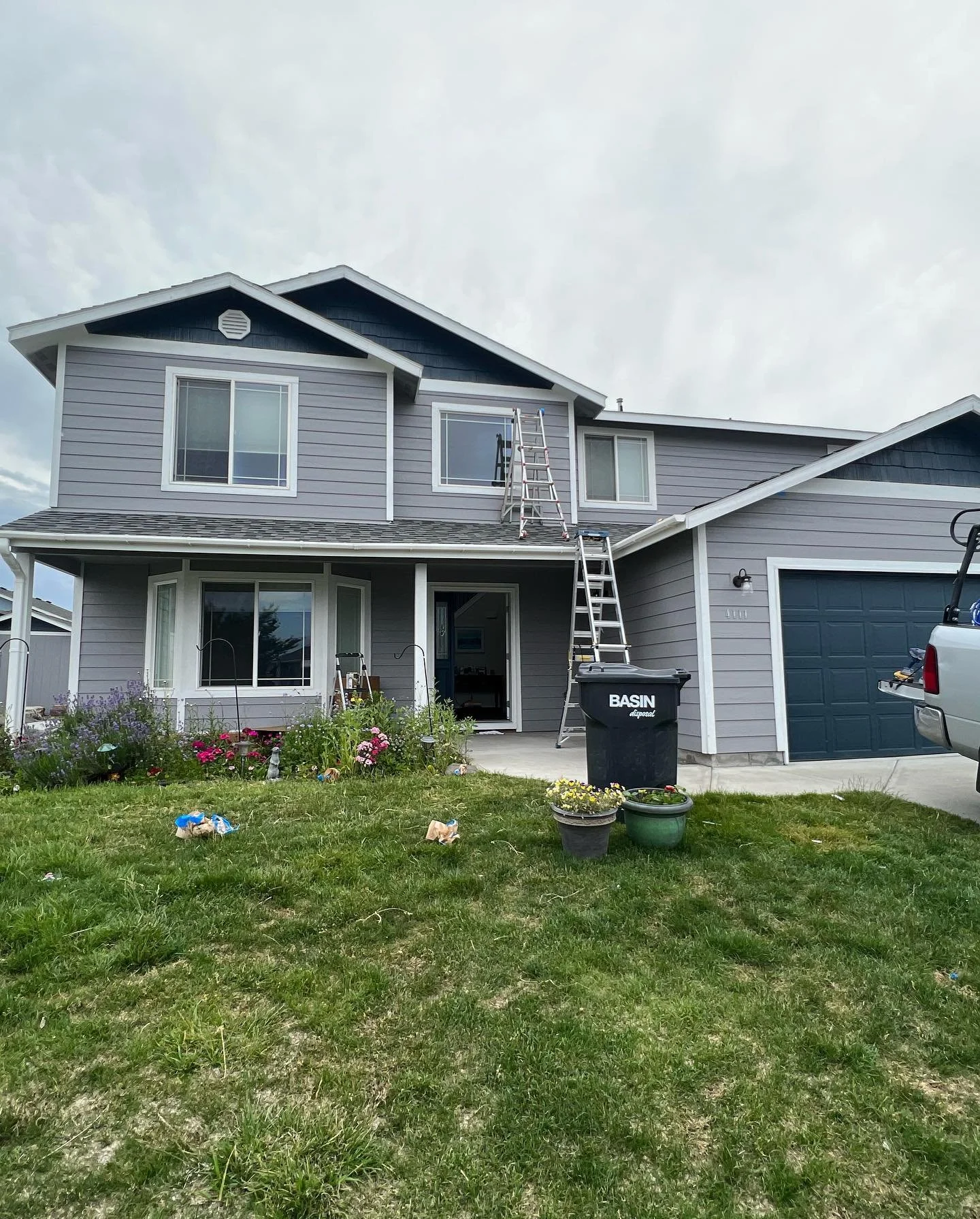 Two-story home with grey siding and white trim nearly finished