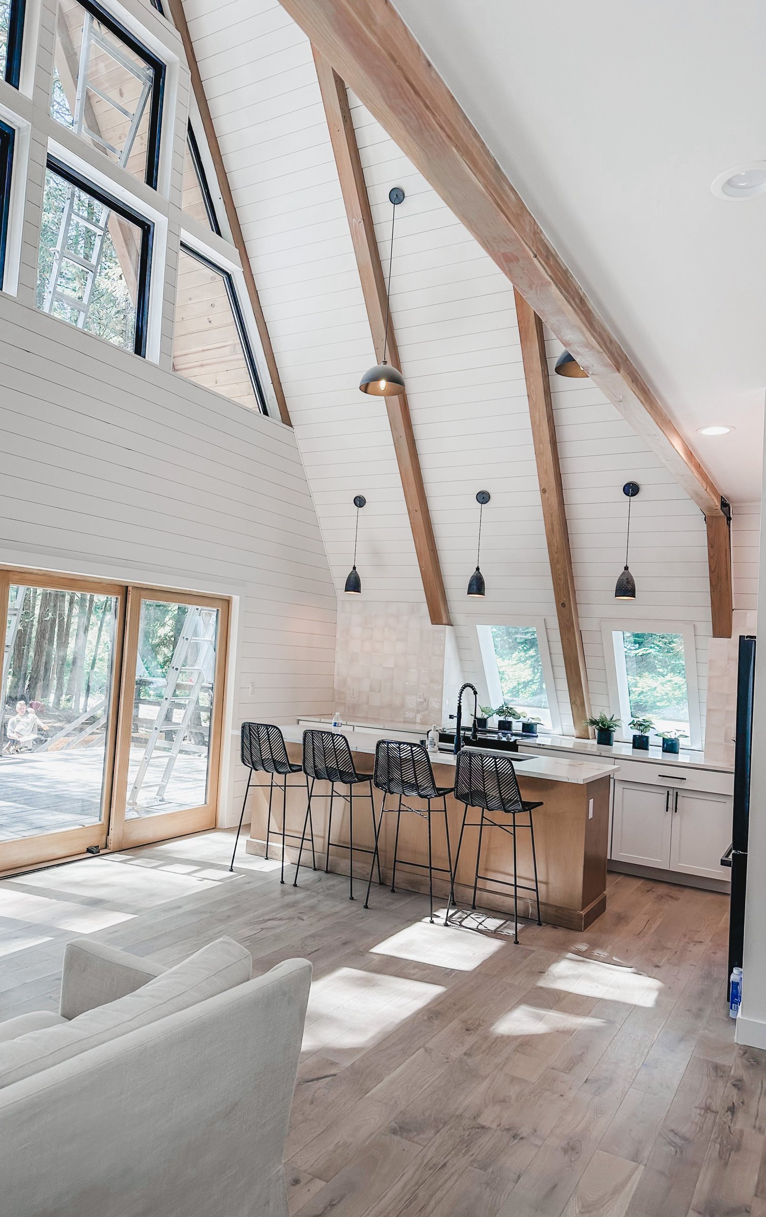 Open-concept kitchen and living area with vaulted ceiling and wooden beams