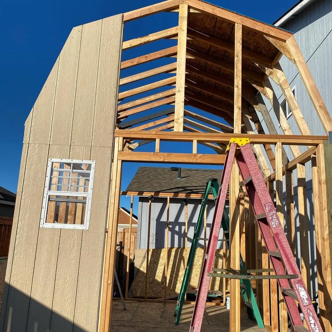 Wooden shed under construction with exposed framing and arched roof
